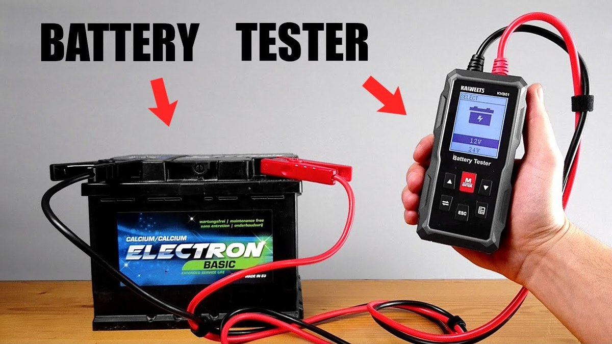 Mechanic using a battery tester to check a vehicle battery in a service bay