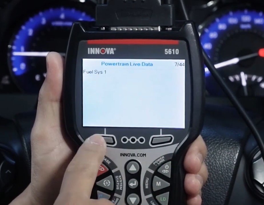 Innova 5610 scan tool connected to a vehicle dashboard, showing code reading and live data functions