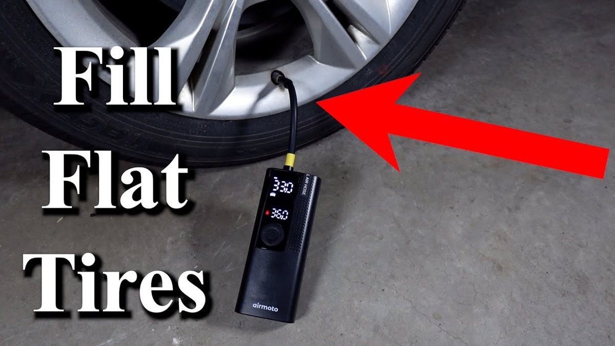 Driver checking tire pressure gauge beside a portable tire inflator connected to a car tire