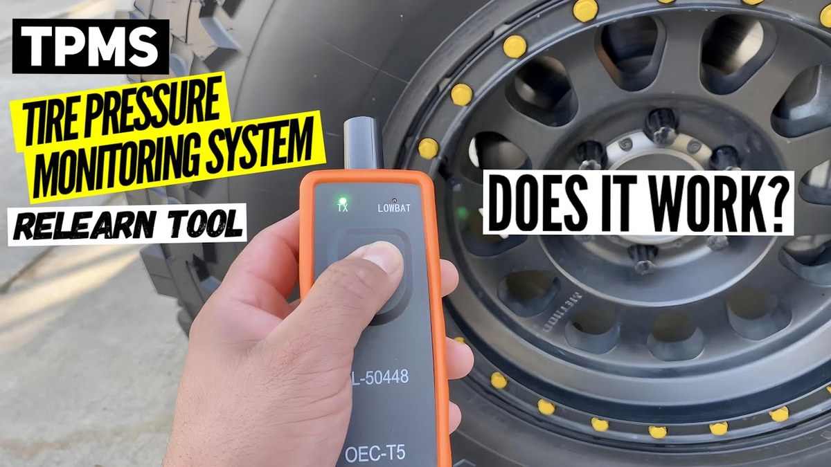 Technician using a TPMS reset tool to reprogram tire pressure sensors after service