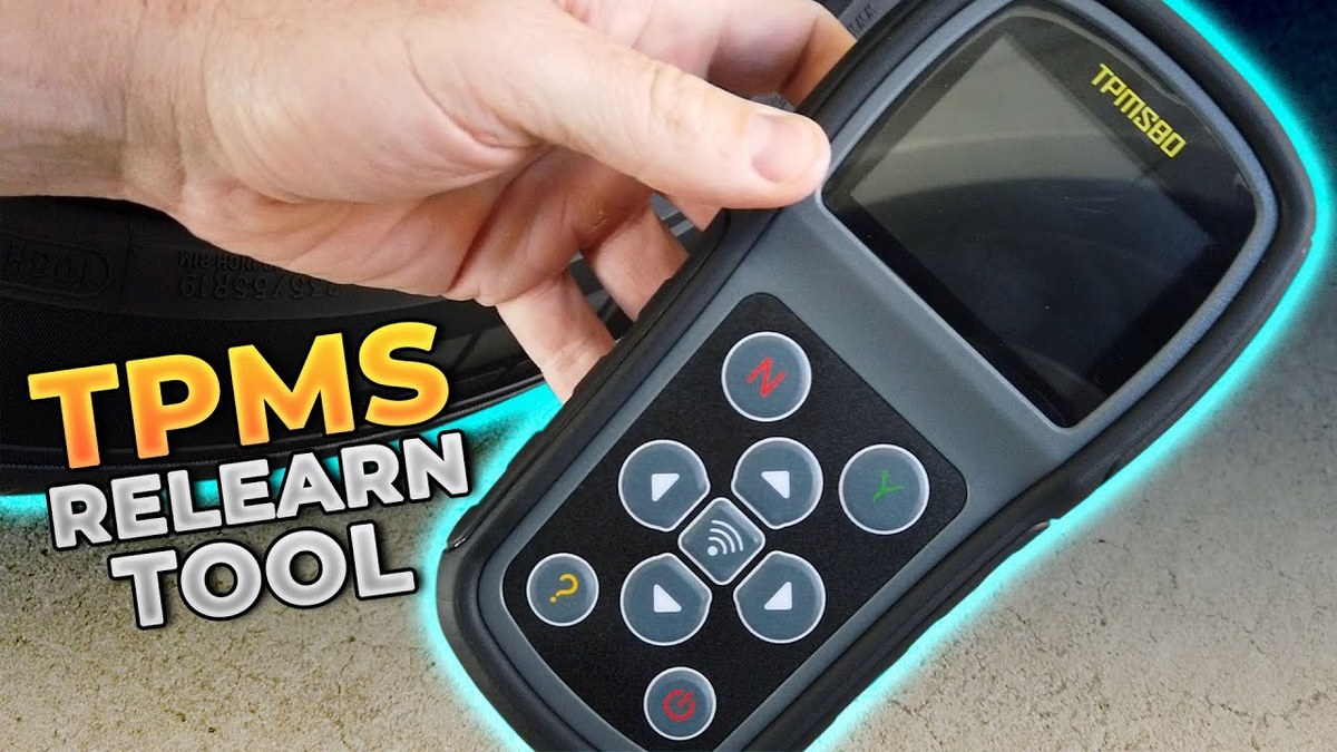 Driver pressing TPMS reset button inside a parked car while dashboard tire pressure warning light is on