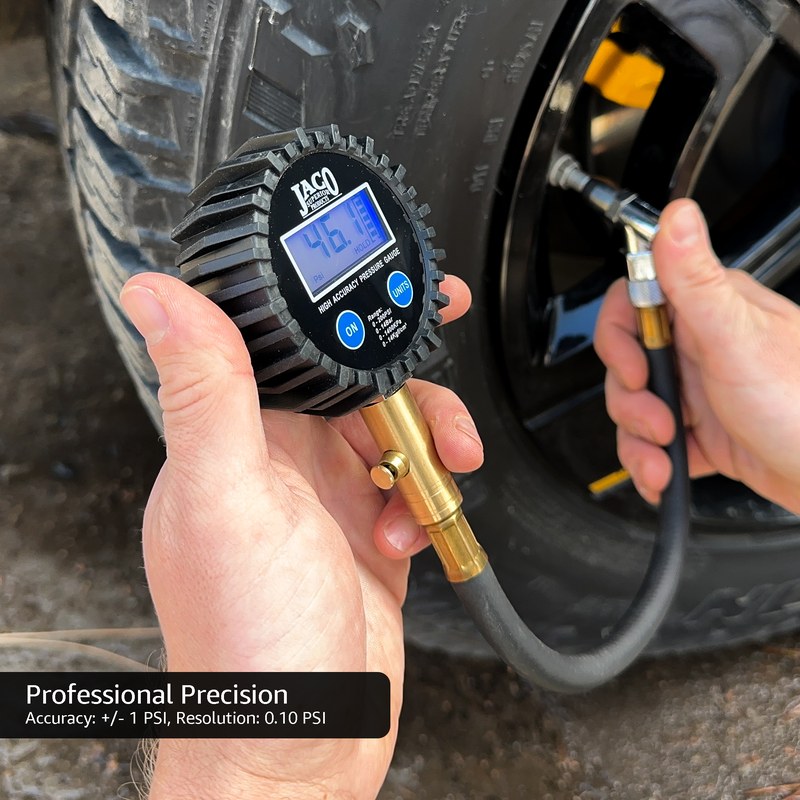Portable tire inflator gauge attached to a tire valve stem, displaying the current pressure reading.