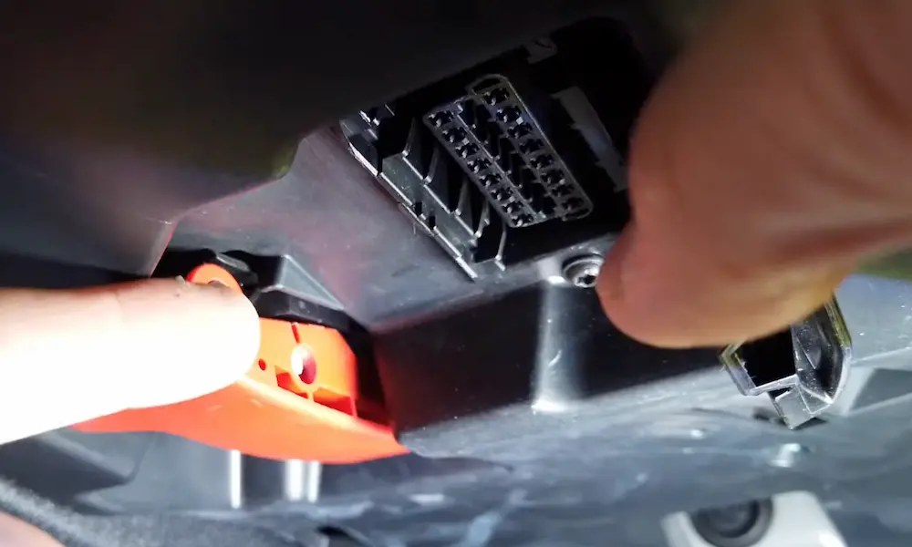 OBD2 port under the dashboard with a scanner cable connected, ignition in accessory mode