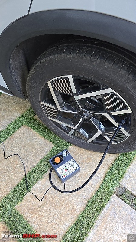 Tire inflator display showing set pressure and actual pressure, hose connected to car tire valve for diagnosis.